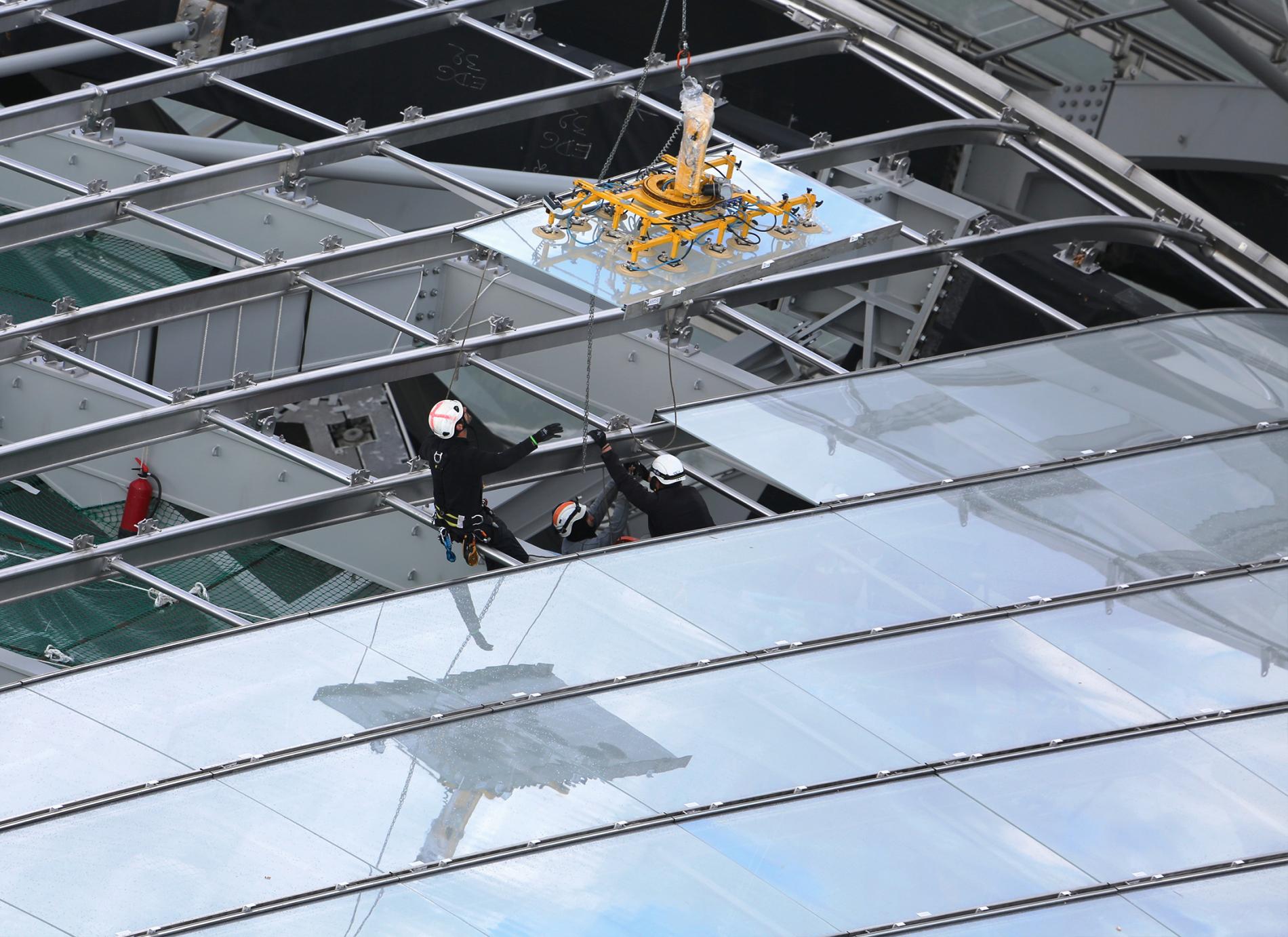 Pose des vitrages sur une des voiles vitrées de la Fondation Louis Vuitton. Pose d'un vitrage sur une des verrières de la Fondation Louis Vuitton