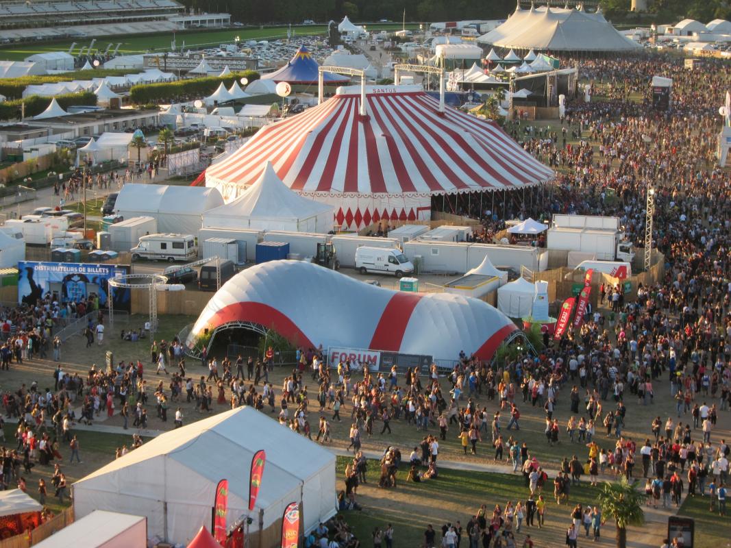 Vue aérienne du site du festival montrant la structure à la toile rouge et argent.