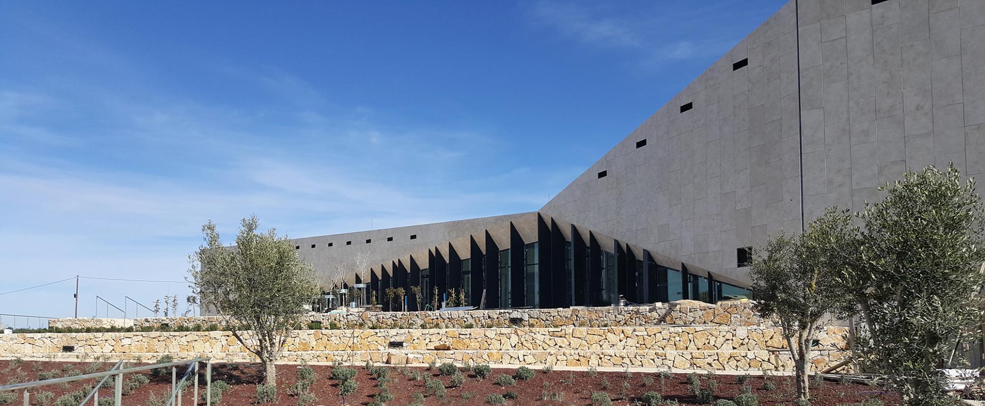 Façades vitrées et enveloppe en pierre du Musée Palestinien.